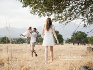 familia en el campo, el padre está alzando a la niña por los aires