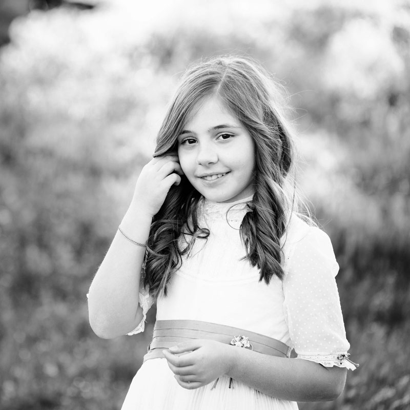 fotografía de una niña sonriente vestida de comunión