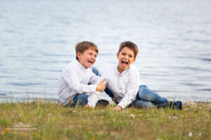 dos niños riéndose delante de un lago