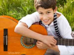 retrato de niño sonriente con guitarra