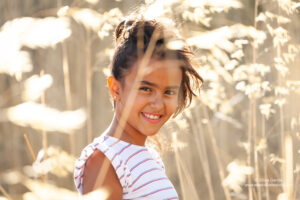 retrato de niña sonriente entre espigas