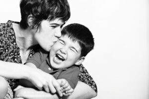 madre besando a su hijo que se ríe