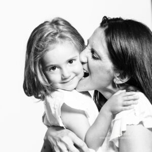 madre mordiendo la mejilla de su hija