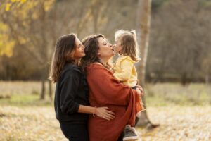 dos mujeres abrazadas con hija en brazos