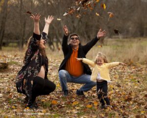 familia tirando hojas al aire en el campo