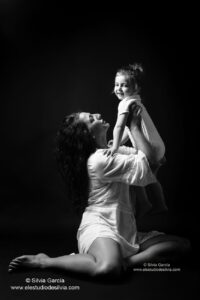 madre alzando a su hija en sus brazos